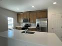 Modern kitchen featuring stainless steel appliances and a large island with a sink at 1758 Tree Shade Dr, Davenport, FL 33837