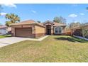 Beautiful single-Gathering home featuring a manicured lawn and an attached two-car garage at 1870 Bridgeview Cir, Orlando, FL 32824