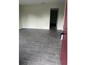 Bright living room featuring modern gray wood-look tile flooring and neutral wall paint at 1926 Kingsland Ave, Orlando, FL 32808