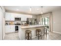 Modern kitchen featuring white cabinets, stainless steel appliances, and a granite countertop island with bar seating at 2293 Pecos Ct, Kissimmee, FL 34759