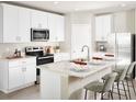 Modern kitchen featuring white cabinetry, stainless steel appliances, and a large island with bar seating at 2306 White Tail St, Davenport, FL 33837