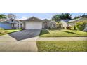 Inviting single-Gathering home featuring a well-kept lawn, concrete driveway, and neat landscaping at 2417 Hybrid Dr, Kissimmee, FL 34758