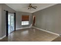 Neutral living room featuring tile flooring, a ceiling fan, and outdoor access at 2602 Talon Ct, Orlando, FL 32837