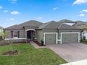 Charming single-story home boasts a brick driveway, two-car garage, and neatly kept lawn at 2620 Cedar Shake Ct, Oviedo, FL 32765