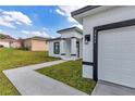 View of the home's exterior with an attached two-car garage and manicured lawn at 2844 Sw 162Nd Street Rd, Ocala, FL 34473