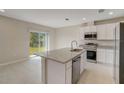 Bright kitchen featuring stainless steel appliances, an island, and sliding glass doors to the backyard at 315 Marquee Dr, Kissimmee, FL 34758