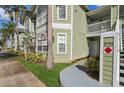 Close up of condo building with light green siding, white trim, and a walkway to the entrance at 3151 Britannia Blvd # A, Kissimmee, FL 34747