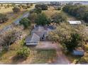 Aerial view of a charming single-story home with fenced yard and large trees on a spacious rural lot at 37224 Apiary Rd, Grand Island, FL 32735