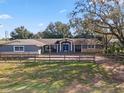 Charming single-story home with blue door, stone accents, and inviting front porch at 37224 Apiary Rd, Grand Island, FL 32735