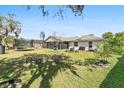 A spacious backyard with a lawn, mature trees, trampoline, and outdoor seating area, perfect for entertaining and relaxation at 4100 Cannon Ct, Kissimmee, FL 34746