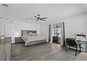 Bright main bedroom featuring wood-look floors, neutral walls, ceiling fan, and sliding glass doors to the backyard at 4100 Cannon Ct, Kissimmee, FL 34746