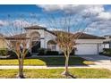 A well-maintained single Gathering home boasts a manicured lawn and a classic color scheme on a sunny day at 418 Laurenburg Ln, Ocoee, FL 34761