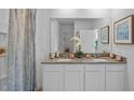 Bright bathroom featuring a granite countertop with dual sinks, white cabinetry, and decorative accents at 4253 Singing Mockingbird Blvd, Bartow, FL 33830