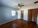 Bedroom with hardwood floors, ceiling fan, closet with bifold doors, interior door and a sunlit window at 9 Lake Dr, Debary, FL 32713