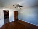 Spacious bedroom with hardwood floors, ceiling fan, closet with bifold doors, and interior door at 9 Lake Dr, Debary, FL 32713