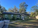 Lovely green single-story home with a front yard, walkway, and driveway, perfect for a cozy living at 9 Lake Dr, Debary, FL 32713