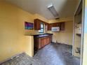 Bright kitchen featuring wood cabinets, black counters, and a microwave, ready for renovation at 115 S Lake Pleasant Rd, Apopka, FL 32703