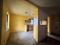 Open-concept kitchen and dining area with wood cabinets, yellow paint, and laminate flooring at 115 S Lake Pleasant Rd, Apopka, FL 32703