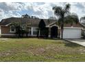 Charming single-story home featuring a well-manicured lawn and lush tropical landscaping at 121 Loma Bonita Dr, Davenport, FL 33837