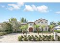 Beautiful home with well-manicured landscaping, a tile roof, and a circular driveway at 135 James Pl, Maitland, FL 32751