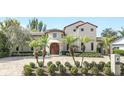 An inviting home featuring mature landscaping, a circular driveway, and a tiled roof at 135 James Pl, Maitland, FL 32751