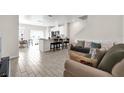 Bright, open-concept living space with tile floors, modern furniture and kitchen island with bar stool seating at 1623 Mirabella Cir, Davenport, FL 33897