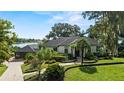Charming home boasts manicured landscaping, palm trees, and picturesque water views at 17201 Magnolia Island Blvd, Clermont, FL 34711