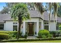 Inviting home entrance features a dark wood door, manicured bushes, and stone pathway at 17201 Magnolia Island Blvd, Clermont, FL 34711