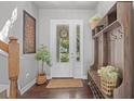 Inviting entryway with coat rack, wood floors, and a decorative door, providing a warm welcome to the home at 1744 Setting Sun Loop, Casselberry, FL 32707