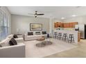 Bright living room featuring modern furniture, a ceiling fan, and seamless access to the kitchen at 211 Stardale Ln, Altamonte Springs, FL 32714