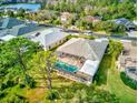 Aerial view of a home with a screened in pool and lush greenery, including a view of the nearby lake at 2439 Teton Stone Run, Orlando, FL 32828