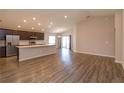 Open-concept living space featuring wood-look flooring, recessed lighting, and sliding glass doors at 2447 Matterhorn Trl, Davenport, FL 33837