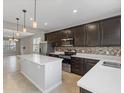 Well-equipped kitchen with stainless steel appliances, an island, dark wood cabinets, and pendant lighting at 2682 Mead Ave, St Cloud, FL 34771