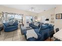 Bright living room with plush blue seating and views of the screened in pool at 302 Vista Loop, Davenport, FL 33897