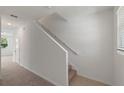 Carpeted staircase with white railings, and natural light coming in from the window at 3349 Vesara Dr, Davenport, FL 33837