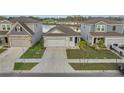 Charming single-story home featuring a gray exterior, attached garage, and manicured front yard with a pond view at 4057 Sagefield Dr, Harmony, FL 34773