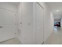 Bright hallway with white walls, closet, and tile flooring leading to the living area at 4057 Sagefield Dr, Harmony, FL 34773