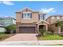 Charming two-story home with a brick driveway, attached two-car garage, and lovely landscaping at 431 Novi Path, Kissimmee, FL 34747