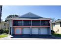 Condominium featuring private garages and balconies with black metal railing at 4448 Pinebark Ave # 56-1, Orlando, FL 32811
