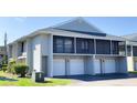 Condo exterior with garages and a second-story screened in balcony at 4448 Pinebark Ave # 56-1, Orlando, FL 32811