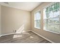 Bright bedroom featuring wood-look flooring and two large windows providing natural light at 4905 Maple Park St, Orlando, FL 32811