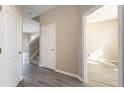 Inviting entryway with gray wood-look flooring and white trim, leading to staircase and adjacent rooms at 4905 Maple Park St, Orlando, FL 32811