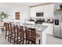 Modern kitchen featuring stainless steel appliances, granite countertops, and a breakfast bar with seating at 4957 Kaia Ave, Winter Haven, FL 33884