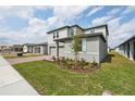 Modern two-story home with grey siding, brick driveway, and fresh landscaping at 4965 Kaia Ave, Winter Haven, FL 33884