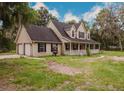 Charming two-story home with a welcoming front porch and a spacious front yard with mature landscaping at 6801 County Rd 665, Bushnell, FL 33513