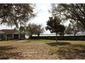Charming single-story home with a well-maintained lawn and mature trees, offering serene lake views at 9130 Laws Rd, Clermont, FL 34714