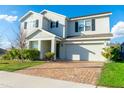Attractive home with a brick driveway, attached garage, manicured front yard, and a welcoming entrance at 9228 Halsey Dr, Groveland, FL 34736