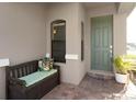 Inviting front porch featuring a bench with cushions and a potted plant by the sage-colored front door at 938 Braewood Dr, Clermont, FL 34715