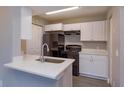 Modern kitchen featuring white cabinets, stainless steel sink, and black appliances at 1015 S Hiawassee Rd # 3514, Orlando, FL 32835