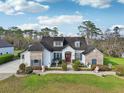 Charming home featuring stone accents, a red front door, and manicured landscaping at 1220 Lake Mills Rd, Chuluota, FL 32766